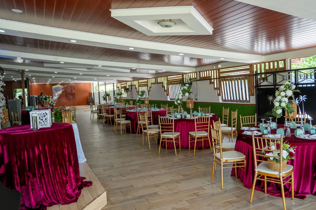 Covered reception area with burgundy tables and gold chairs at Jenny's Ranch