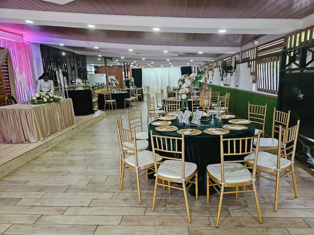 Full reception hall with green and gold table settings at Jenny's Ranch